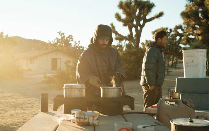 a person cooks over a stove in Joshua Tree National Park